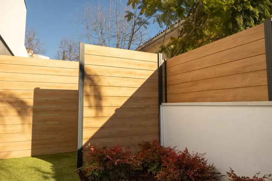 Valla de aluminio efecto madera roble Malta con postes oscuros